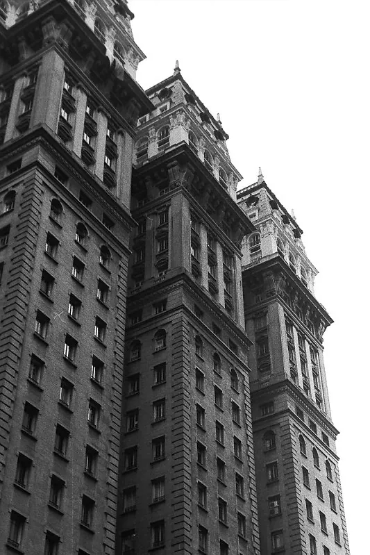 Torres de um edifício histórico visto de baixo, contra o céu claro