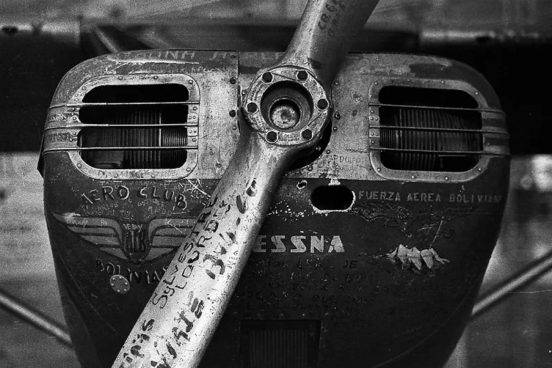 Detalhe da hélice e do motor de um avião Cessna antigo, com inscrições e assinaturas na carenagem